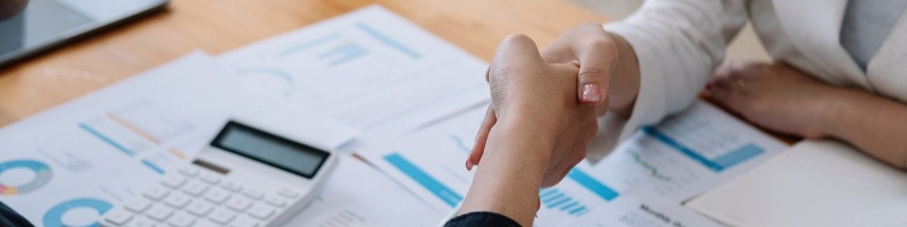 Eine Wissenschaftlerin erklärt einen Sachverhalt vor einer Gruppe von Geschäftsleuten.